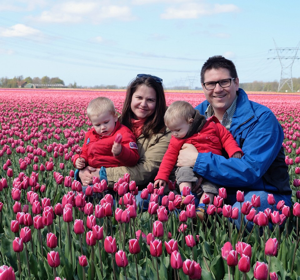 Egy holland tulipán mező közepén ül egy pár a két kisgyermekükkel