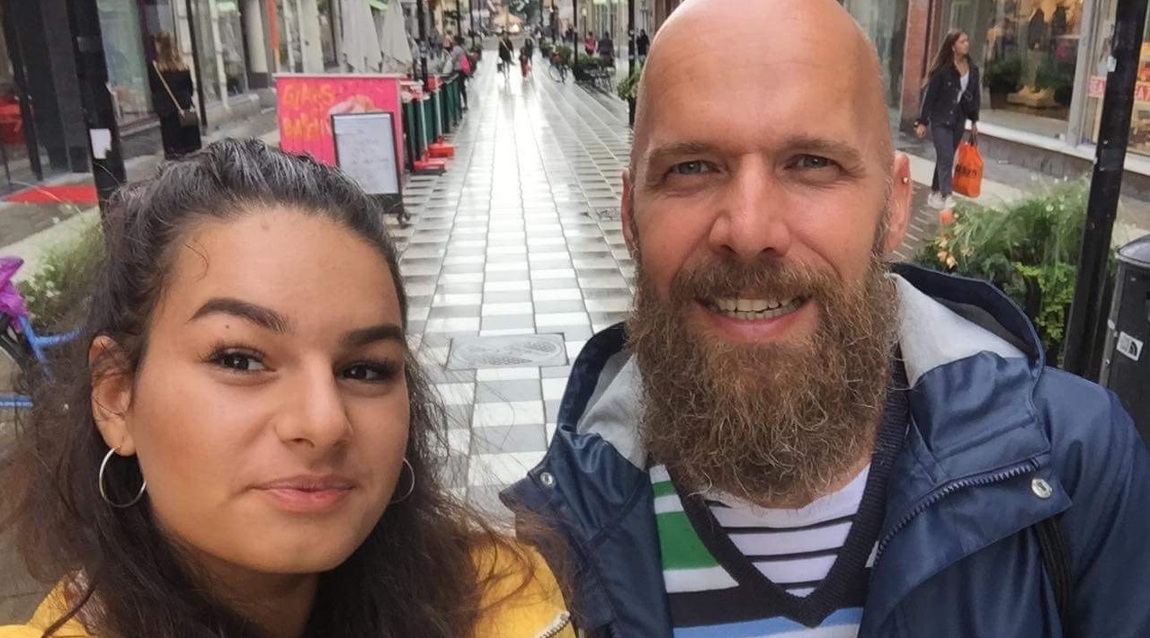 Bevásárló utca elején selfiező fiú és lány mosolyog a kamerába