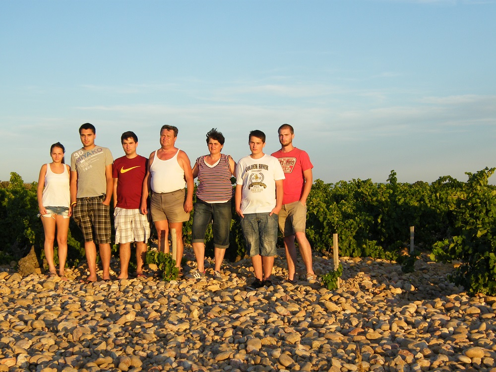 A Dúzsi borász család fotója szülőkkel és a fiatalokkal egy napsütötte szőlőhegyen nyári időszakban