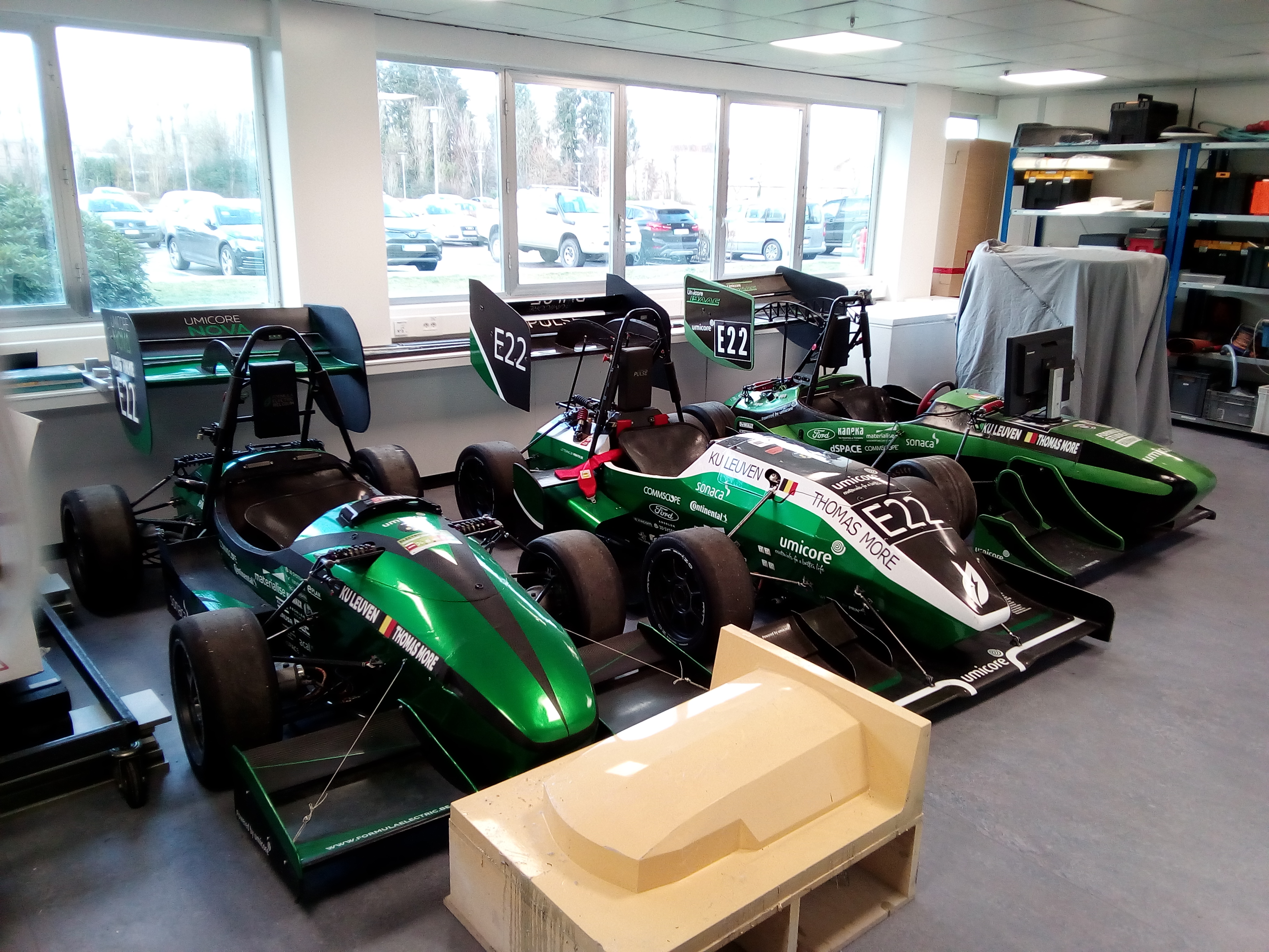 3 darab Forma1 autó egy áll egymás mellett egy teremben