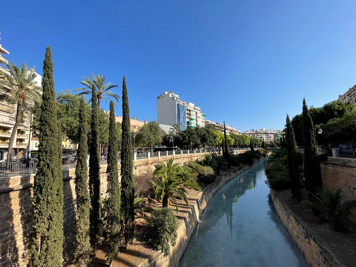 mallorcai folyópart cédrusokkal a háttérben magas épületekkel