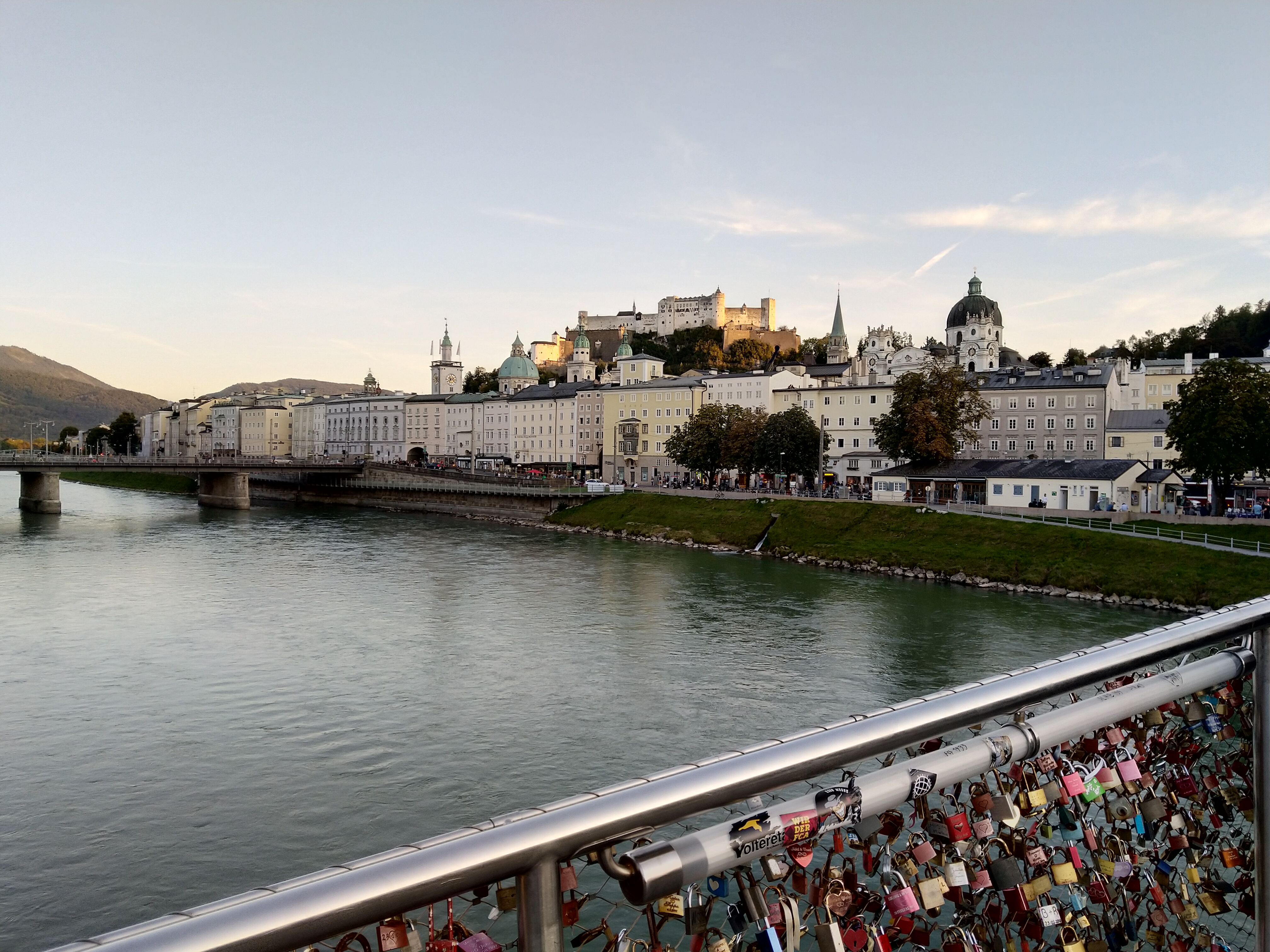 Salzburg városkép egy hídról fotózva a folyó a hidak és a rakparton levő házak és háttérben a vár látképével