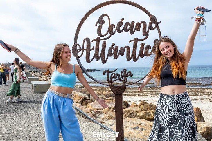 Oceano Atlantico felirat mellett áll két fiatal lány a tengerparti sétány elején